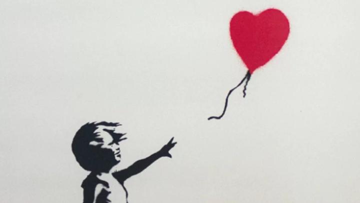 Particolare di un'opera di Bansky, con una bambina che osserva un palloncinoa forma di cuore