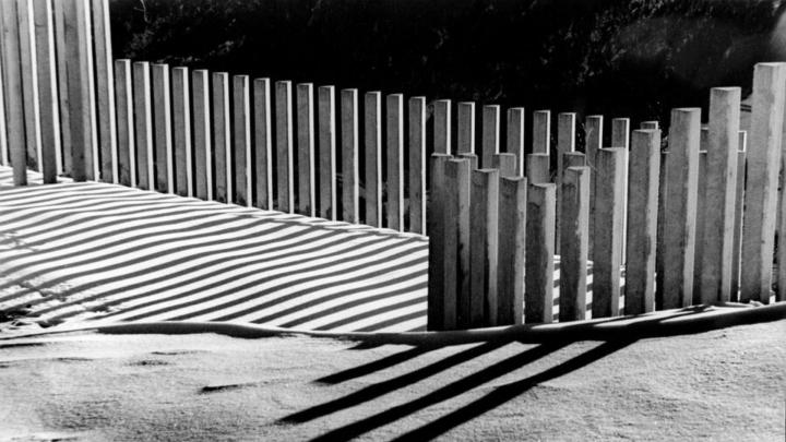 Particolare di fotografia di Francesco Delorenzi dal sito www.fondazionecrbiella.it Fotografia in bianco e nero con palizzata di cemento che proietta ombre su una distesa di neve