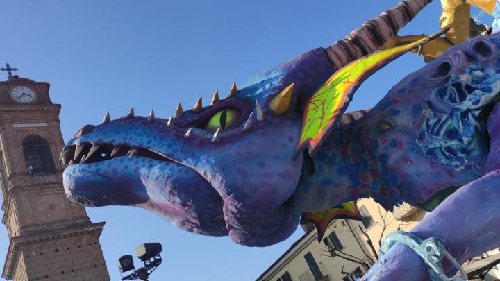 Drago di cartapesta e a sinistra campanile di Giaveno 