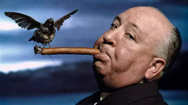 Particolare della fotografia "Il regista Alfred Hitchcock sul set del film Gli uccelli", 1962 © Philippe Halsman Archive 2026 Uomo maturo con sigaro in bocca e un corso posato sul sigaro