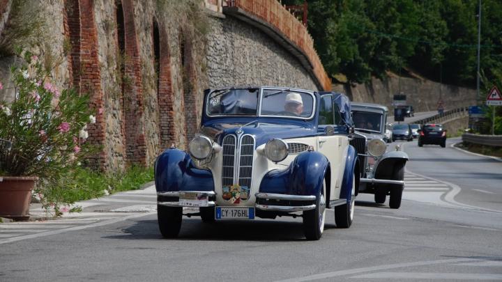 Crediti d'immagine: archivio VisitCuneese, dal sito www.visitcuneese.it Foto di automobile d'epoca su strada asfaltata presso muraglia