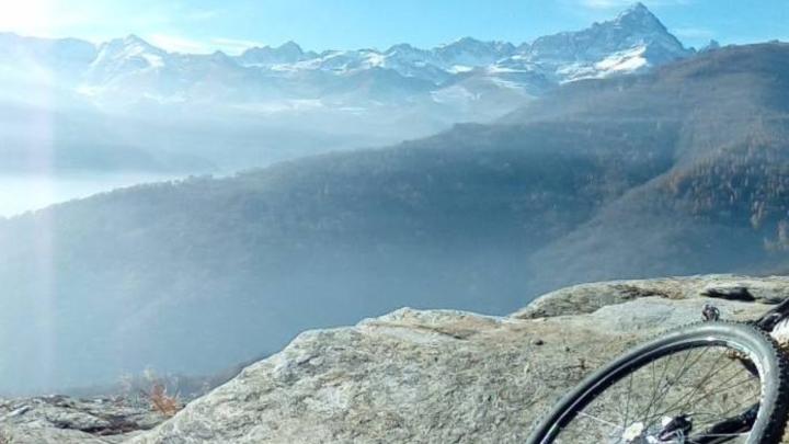 Veduta di montagna e ruota di bicicletta in primo piano