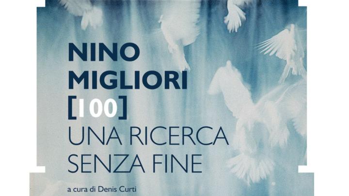 Particolare della locandina della mostra, dal profilo Facebook della Fondazione Ferrero di Alba Titolo e informazioni tra parentesi quadre, sullo sfondo fotografia di Nino Migliori con uccelli in volo e fasci di luce
