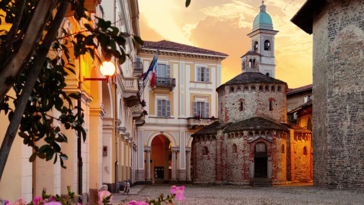 Veduta fotografica al tramonto del Battitero di Biella con edifici circostanti