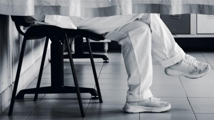 Particolare di foto in bianco e nero con gambe di persona dai pantaloni chiari seduta 