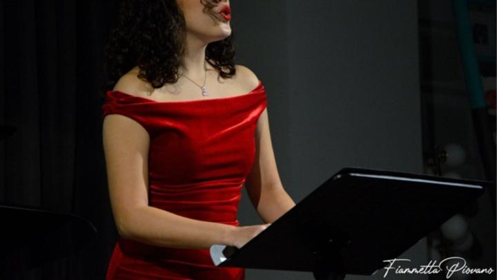 Particolare di fotografia di Fiammetta Pirovano Donna vestita di rosso suona il pianoforte